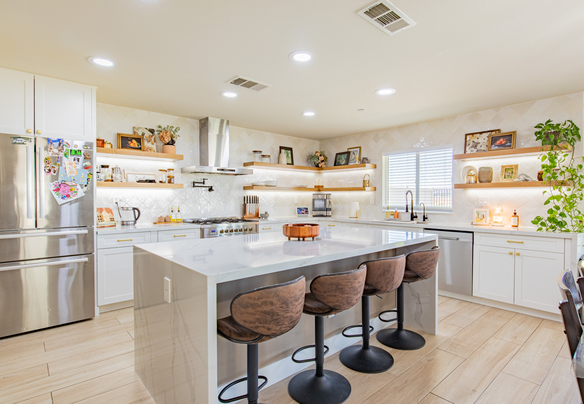 Bright white kitchen with quartz island and open shelving photographed for a listing
